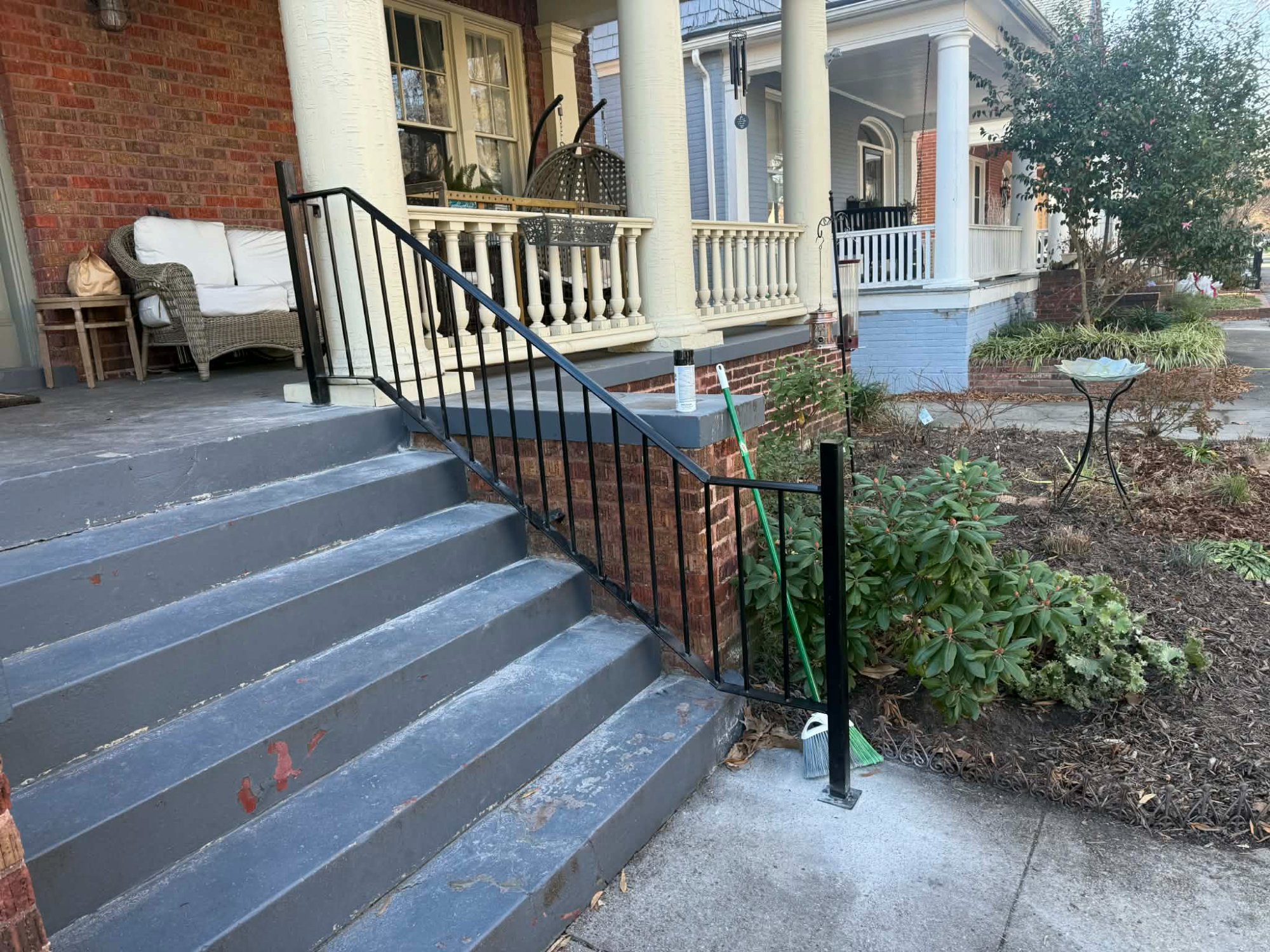 Custom black iron handrail installed on porch steps — 757 Metal Works